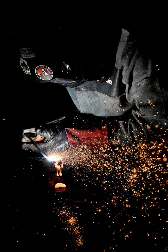 Sparks fly as a welding student works in the dark.
