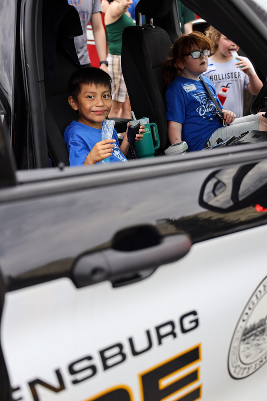 students sitting in police car