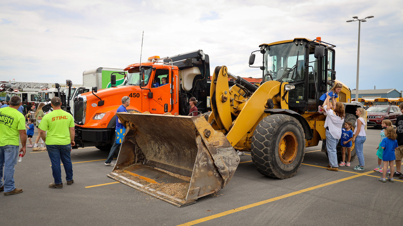 students checking out heavy equipment vehicles in parking lot
