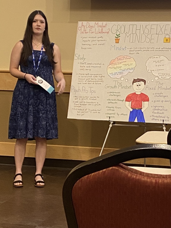 student presents next to display