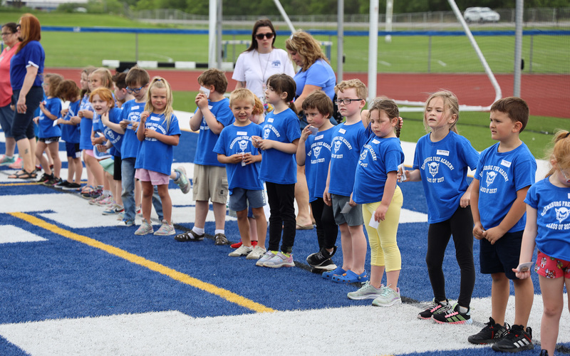 kindergarteners stand in line on field
