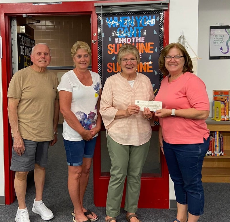 Members of the Snackpack program stand with a check donation.