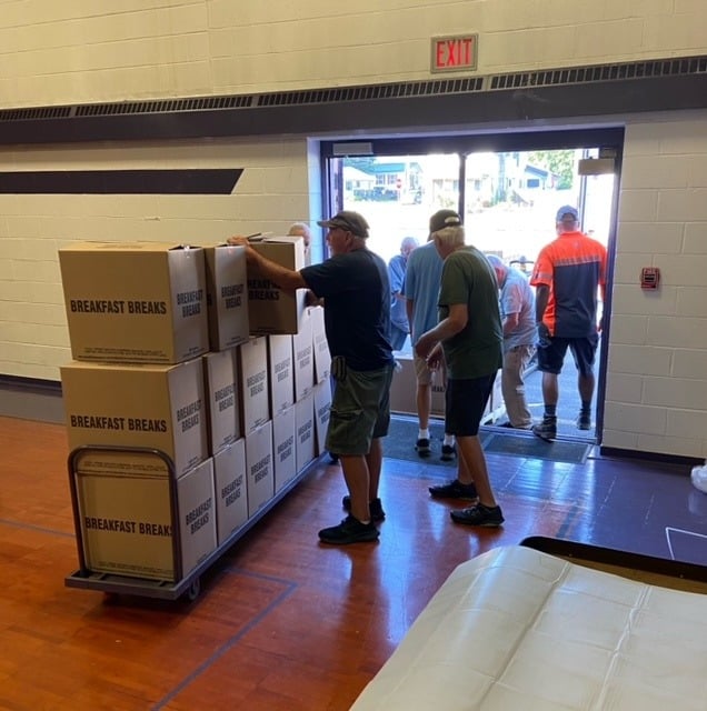 Snackpack program volunteers with boxes of food.